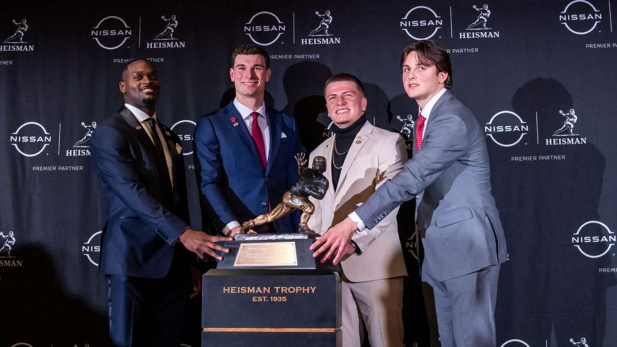 Heisman Trophy finalists, from left to right, Notre Dame running back Jeremiah Love, Indiana quarterback Fernando Mendoza, Vanderbilt quarterback Diego Pavia and Ohio State quarterback Julian Sayin pose with the trophy after attending an NCAA college football news conference before the award ceremony, Saturday, Dec. 13, 2025, in New York.