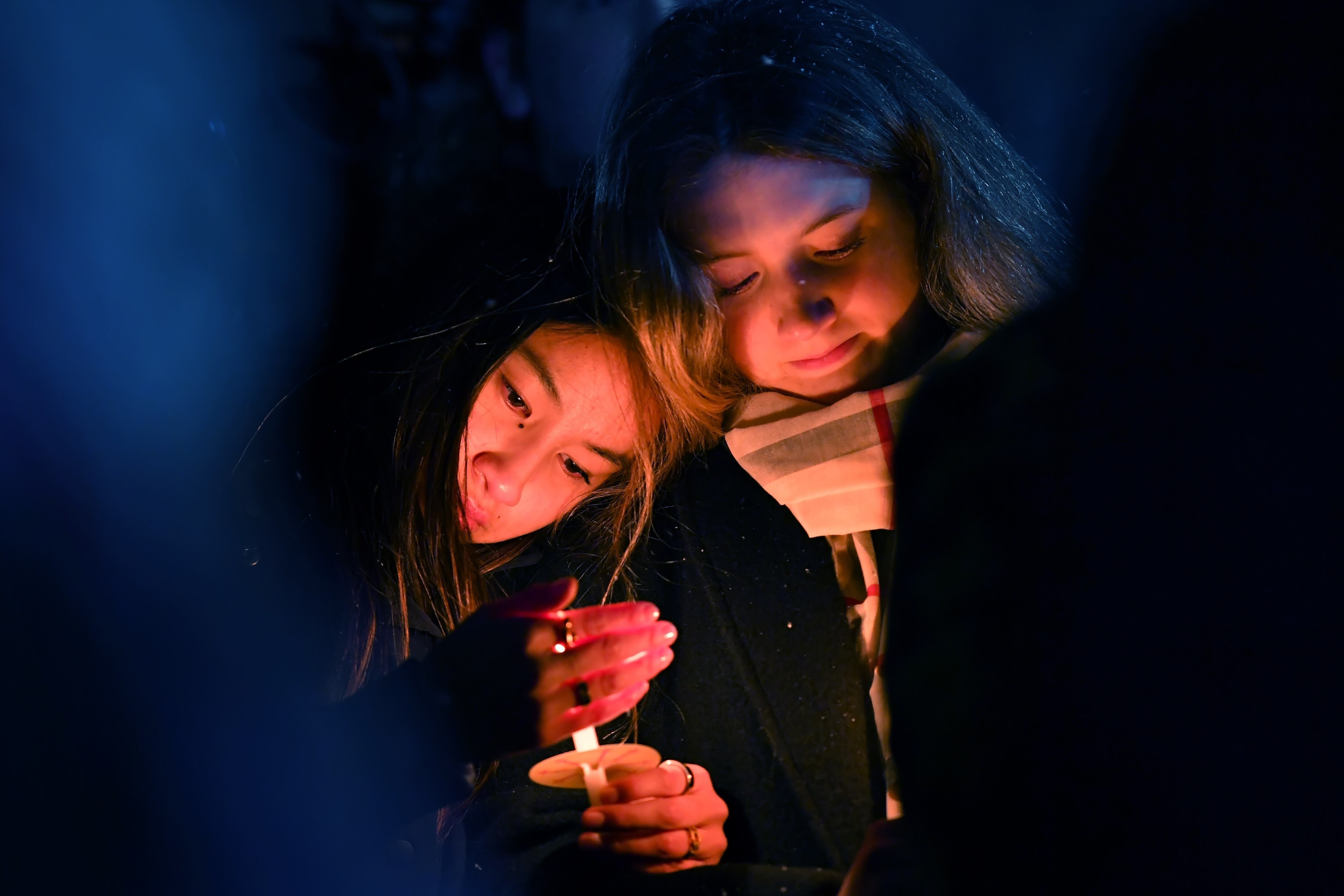 People hold candles during a vigil, Sunday, in Providence, R.I., for those injured or killed in the Saturday shooting on the campus of Brown University.