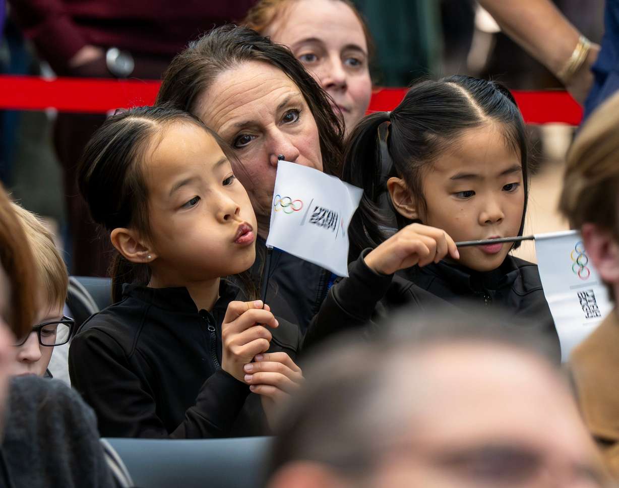 Skating coach Lisa Kriley sits with two of her athletes, Charlotte Gao and Freya Gao, as they attend a ceremony as members of the Organizing Committee for the 2034 Olympic and Paralympic Winter Games, state and local leaders, and former athletes gather to celebrate 3,000 days until the 2034 Winter Olympics during a ceremony at the Salt Lake City International Airport on Nov. 24.