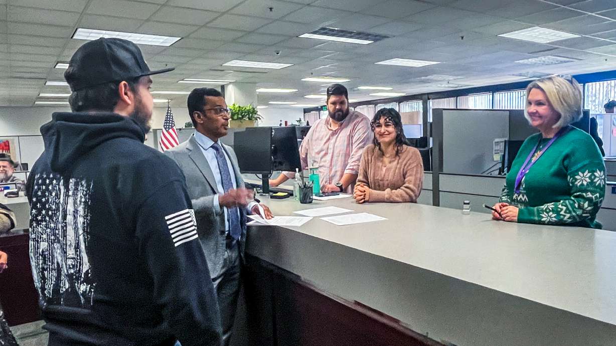 Goud Maragani, center, speaks to Salt Lake County clerk employees before signing a petition for a referendum on Salt Lake County's property tax increase Dec. 15. County officials have allowed the measure to go forward to signature gathering.