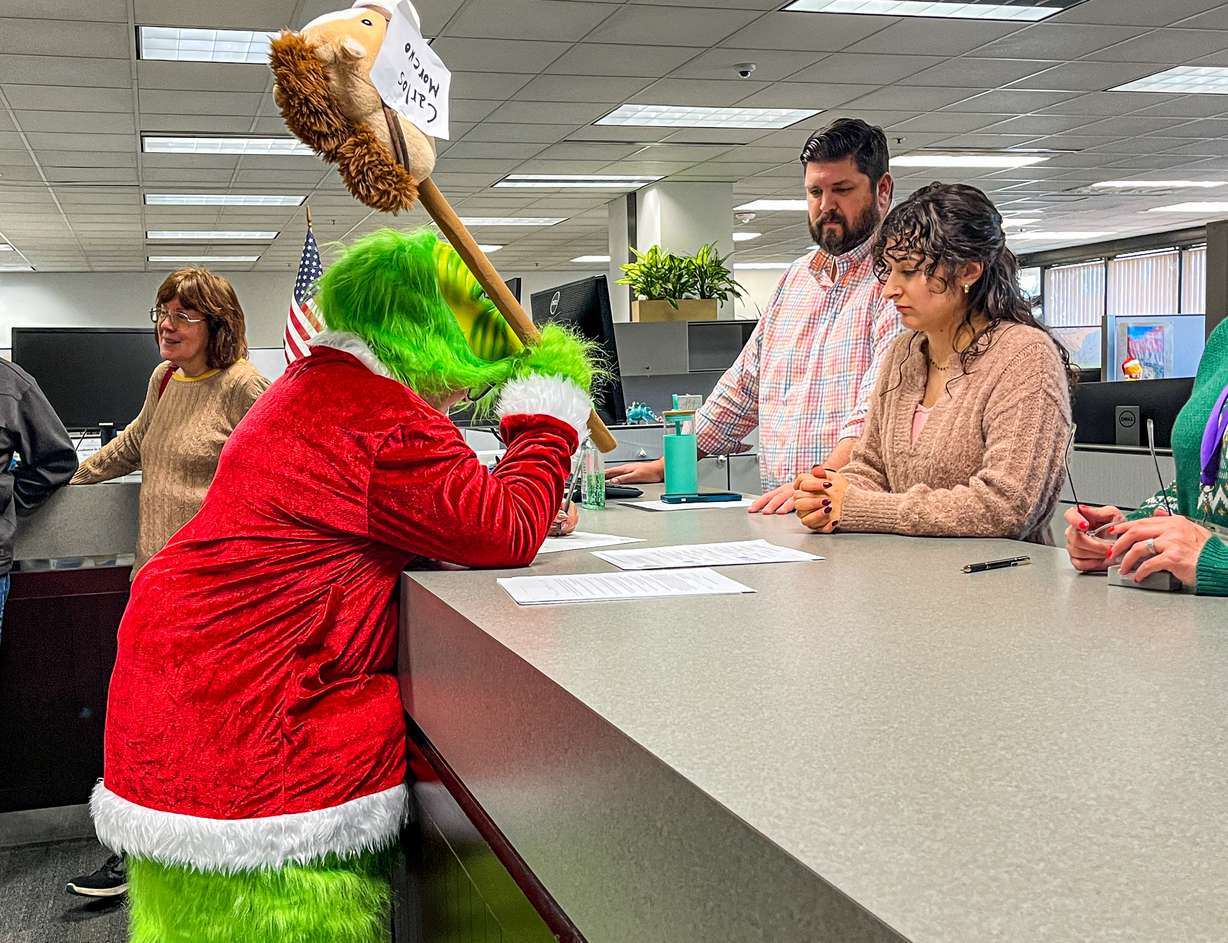 A person dresses as the Grinch while signing for a referendum on Salt Lake County's tax increase on Monday.