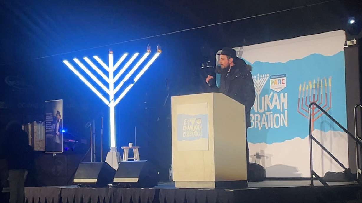 Rabbi Chaim Zippel speaks before a crowd during the Hanukkah celebration at Electric Park in Lehi on Monday.