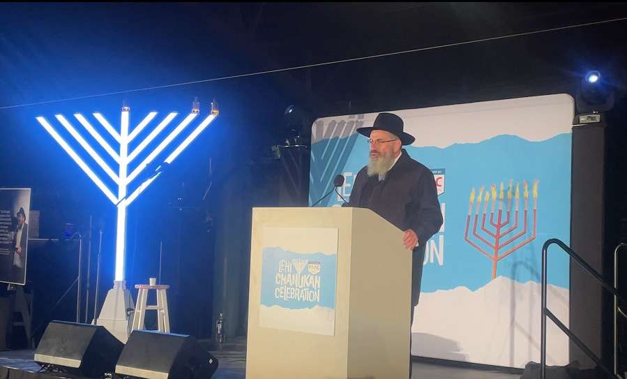Rabbi Chaim Zippel speaks before a crowd during the Hanukkah celebration at Electric Park in Lehi on Monday, Dec. 15, 2025.