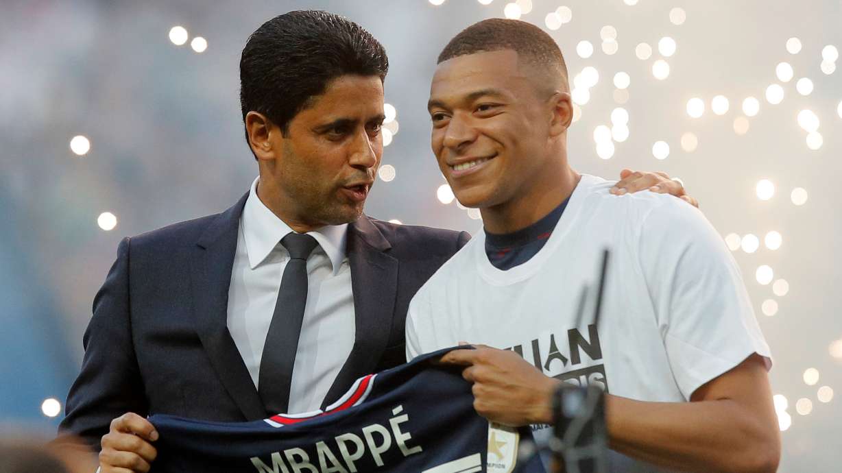 FILE - PSG President Nasser Al-Khelaifi, left, speaks to PSG's Kylian Mbappe as it is announced he has signed a three year extension to his contract, at the Parc des Princes stadium in Paris, France, Saturday, May 21, 2022.