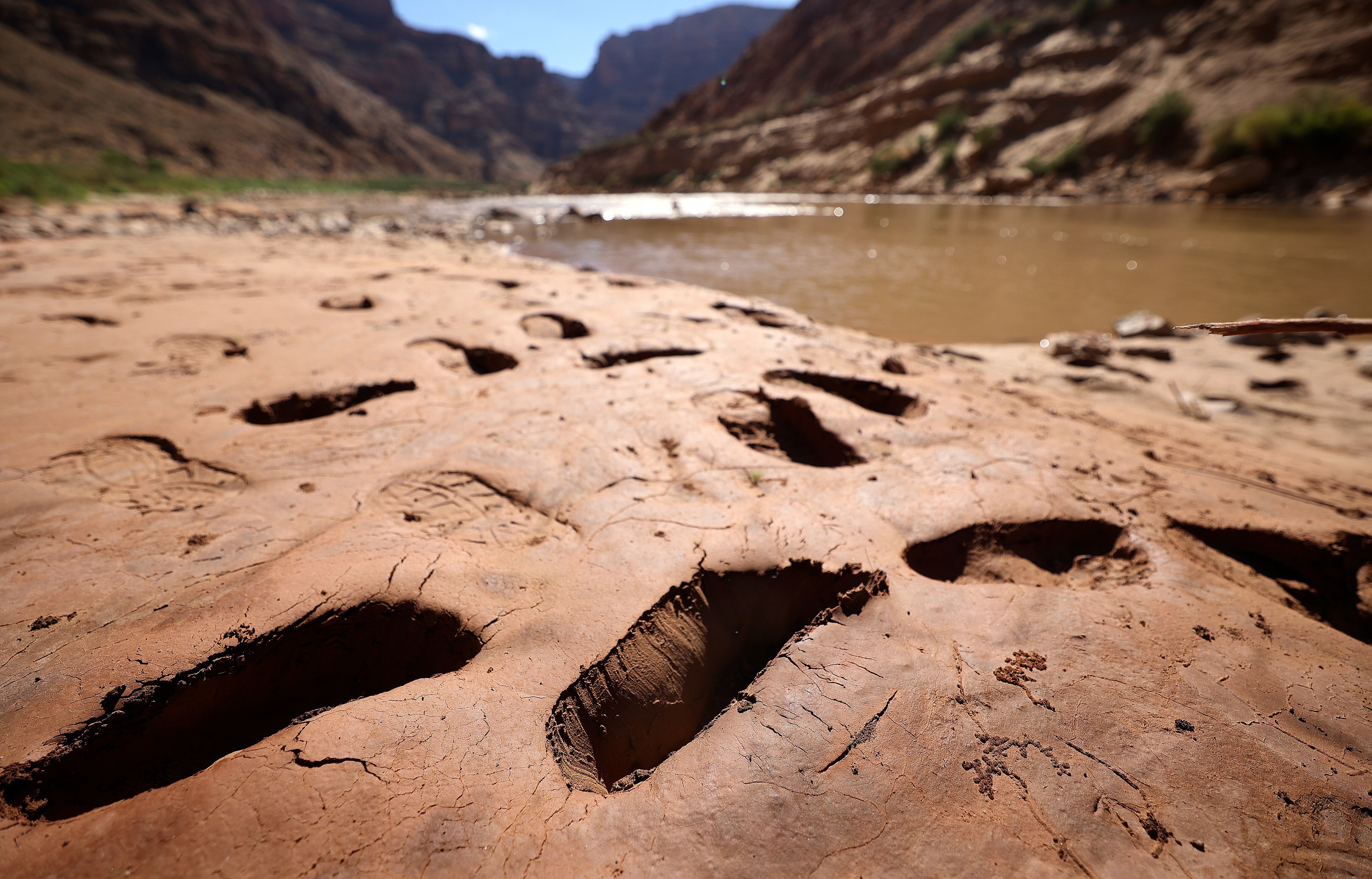 Footprints where people have sunk into mud are pictured above Gypsum Canyon rapid in Cataract Canyon on the banks of the Colorado River on Sept. 20, 2024.
