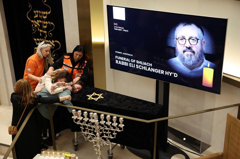 Family members of Rabbi Eli Schlanger, who was killed during Sunday's shooting at Sydney's Bondi Beach, react as they lean over his casket during a funeral at Chabad of Bondi, in Sydney, Australia, Wednesday. He was an assistant rabbi at the synagogue and a father of five.