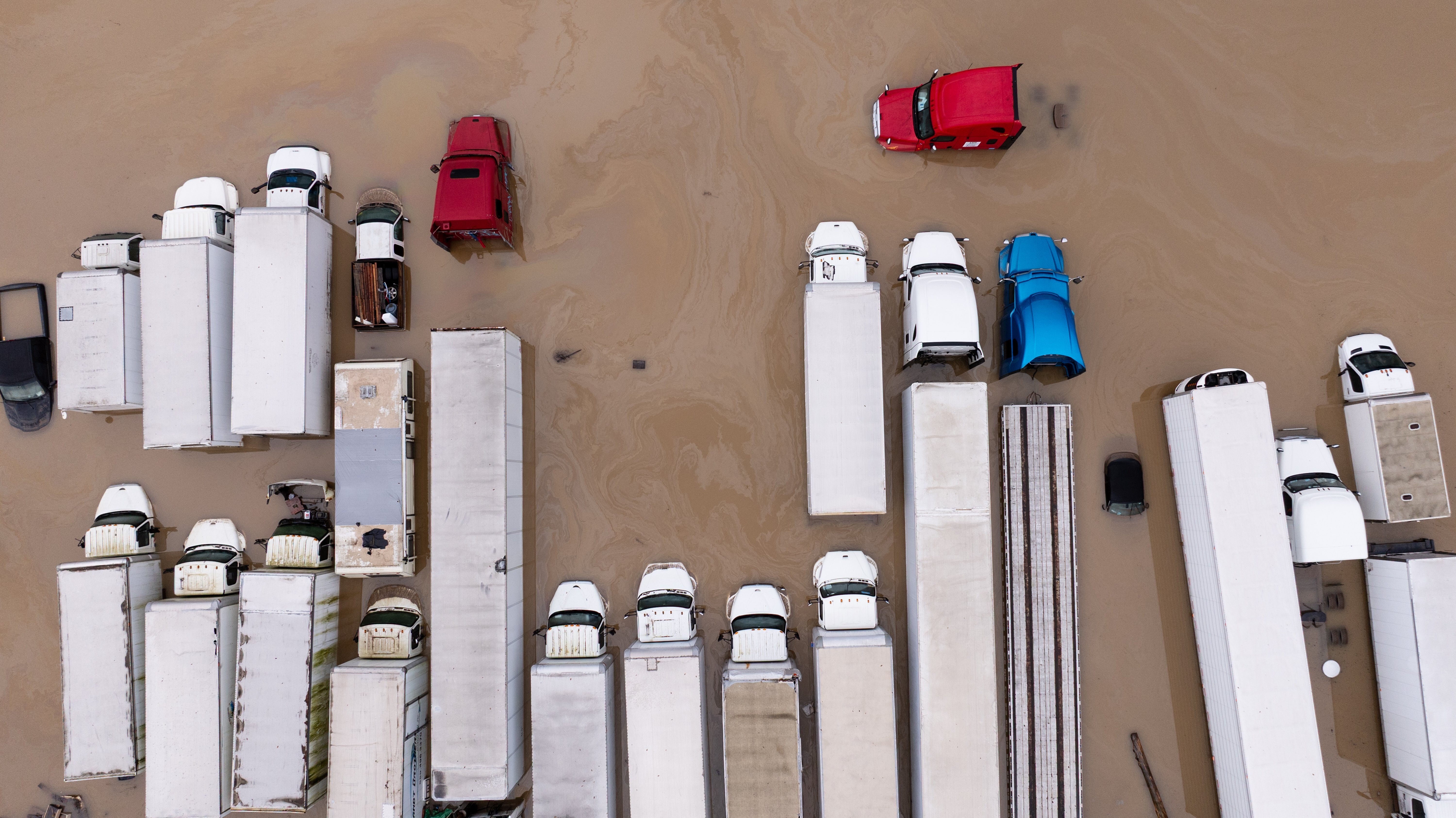 Flood water surrounds trucks from storms, in Kent, Wash., Tuesday. The flood threat in the Northwest remains high with another storm on the way.