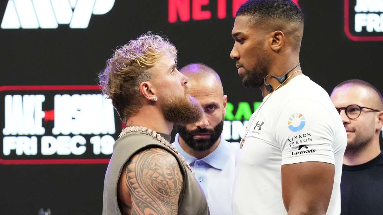 Jake Paul, left, and Anthony Joshua, right, face off during a news conference promoting their upcoming heavyweight boxing match, Friday, Nov. 21, 2025, in Miami.