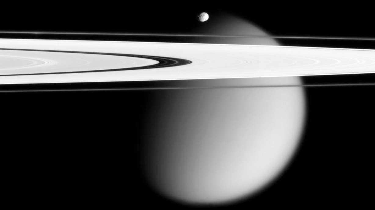 This image made by the Cassini spacecraft and provided by NASA on March 12, 2006, shows two of Saturn's moons, the small Epimetheus and smog-enshrouded Titan, with Saturn's A and F rings stretching across the frame. Saturn's giant moon Titan may not have a vast underground ocean after all.