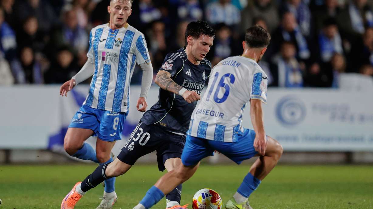 Real Madrid's Franco Mastantuono, center, duels for the balls with Talavera's Iaiah Jeronimo during the Copa del Rey soccer match between Talavera and Real Madrid, in Talavera de la Reina, Spain, Wednesday, Dec. 17, 2025.