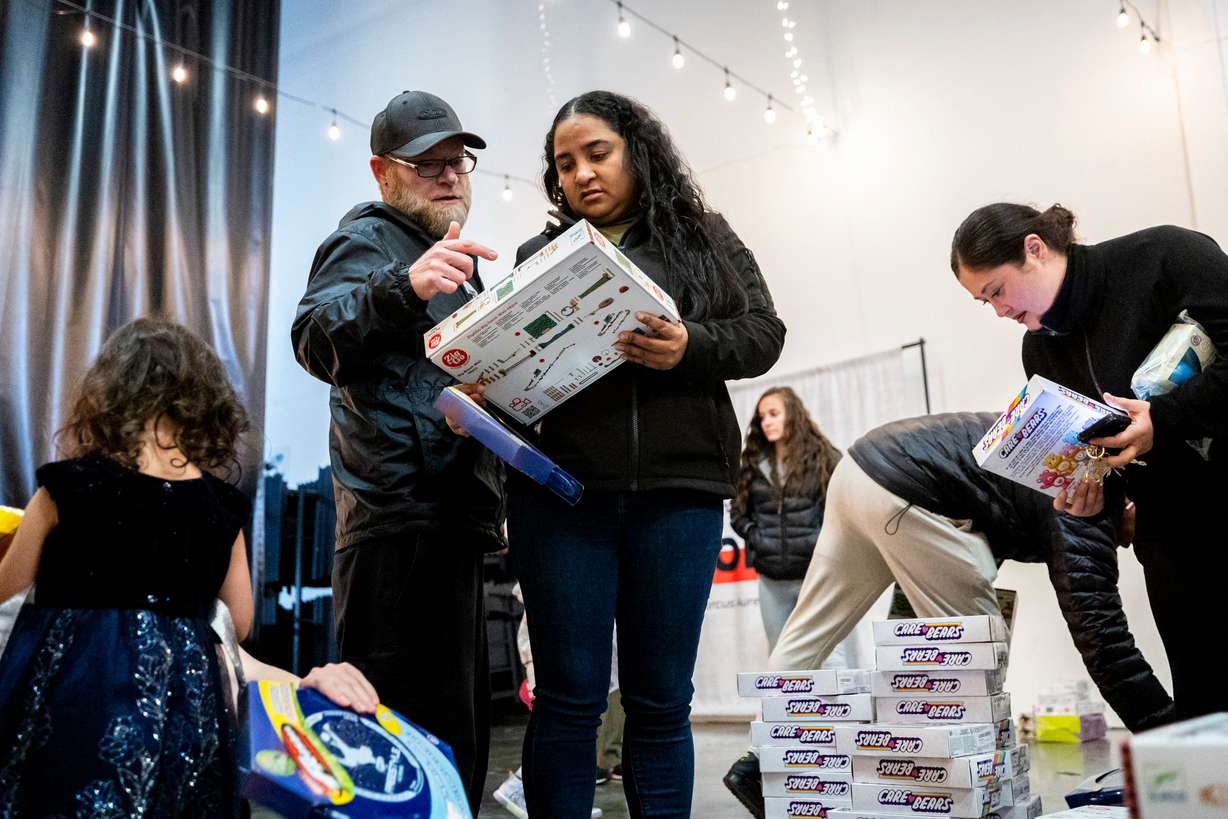 Corry Donathan, left, and Yadira Campo, both of South Jordan, check out toys during a toy drive at the headquarters of We Are The They in Lehi on Wednesday.