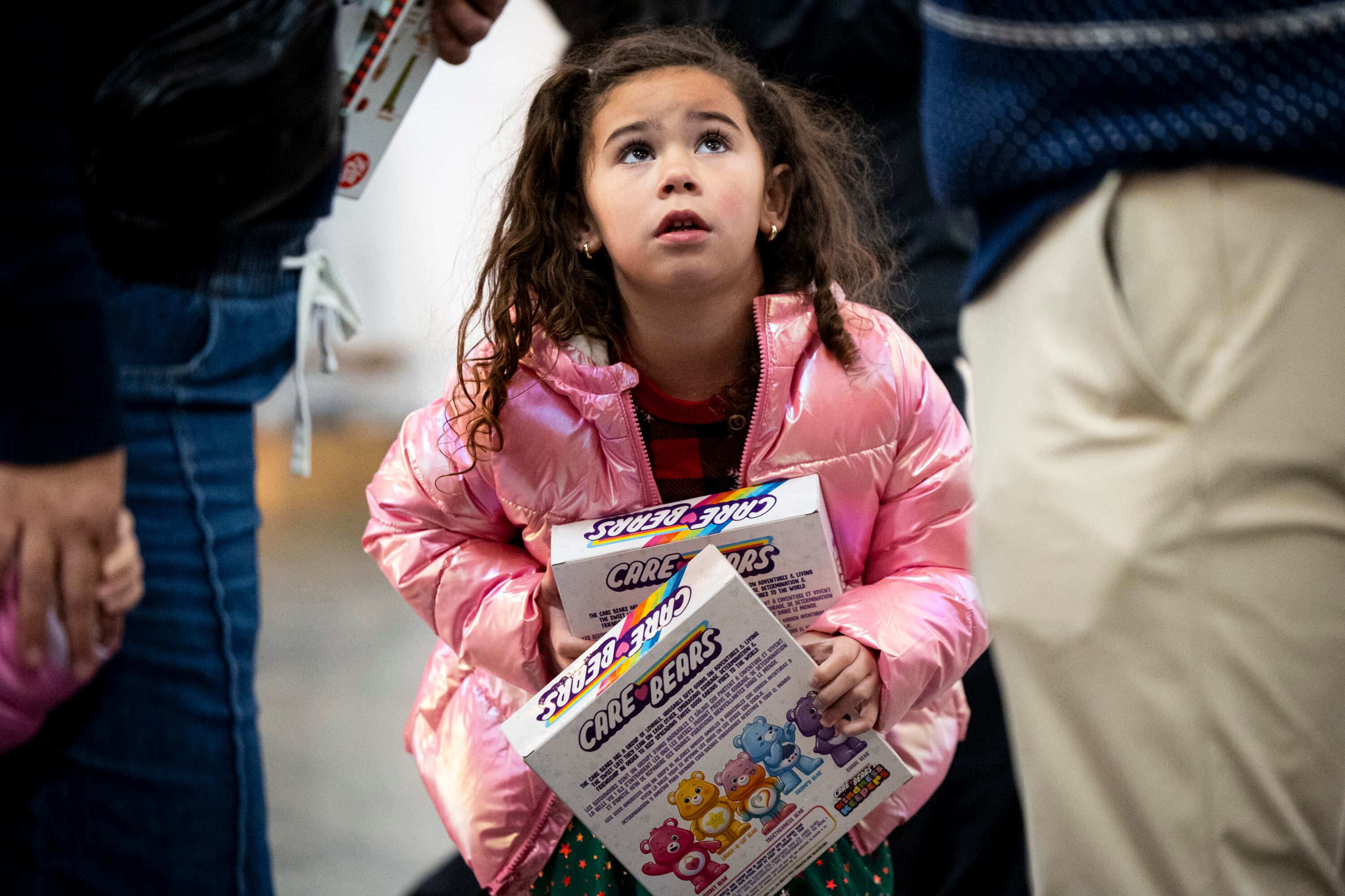 Mia Thornton-Aquino, 4, of Saratoga Springs, holds toys as she listens to her mother get interviewed by a Deseret News reporter during a toy drive at the headquarters of We Are The They in Lehi on Wednesday.