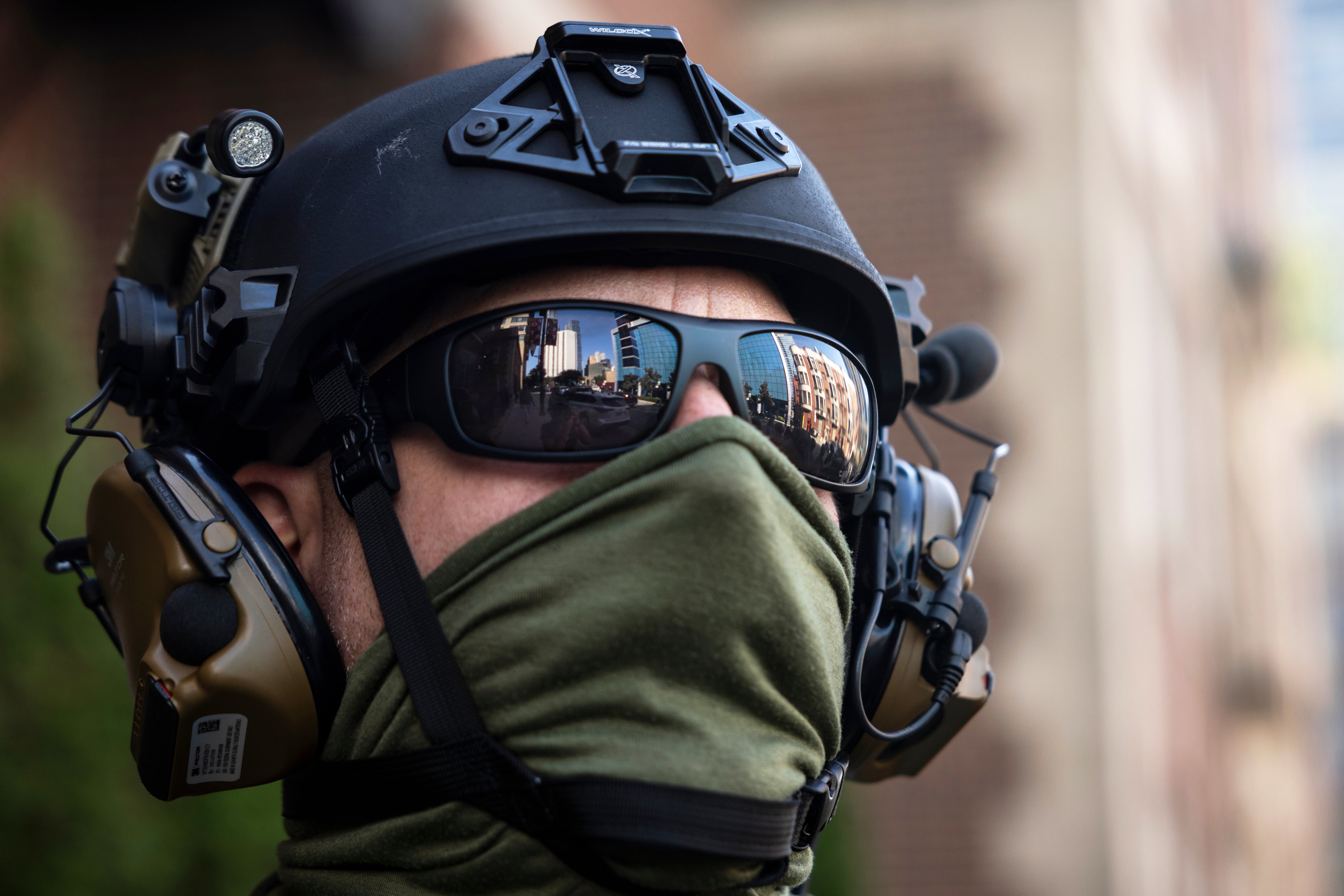 Federal immigration enforcement agents keep watch as they detain a man who took off running as they were walking on North Clark Street near West Superior Street in the River North neighborhood, Sept. 28, in Chicago.
