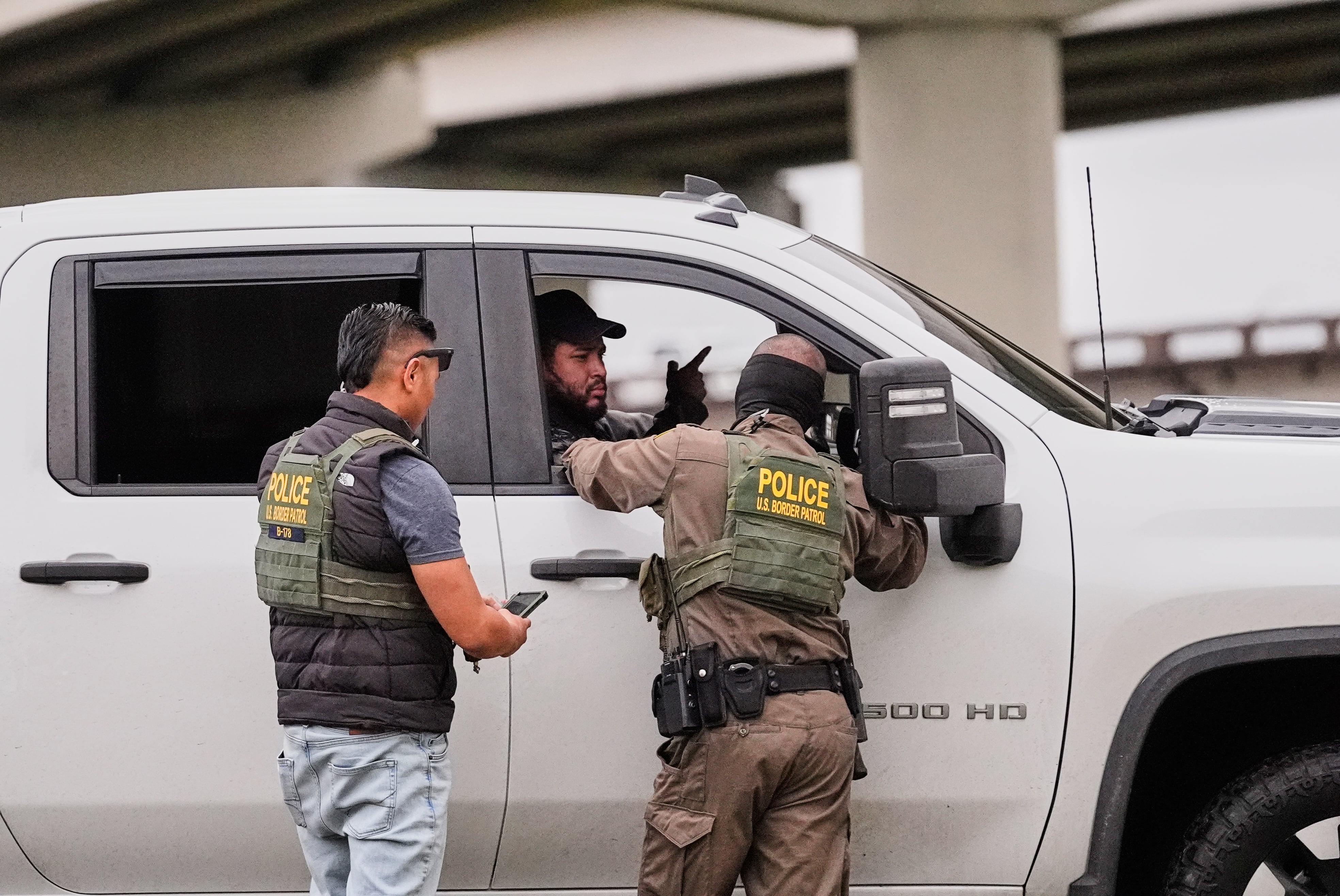 Customs and Border Patrol agents question occupants of a vehicle they pulled over, during an immigration crackdown in Kenner, La., Dec. 5.