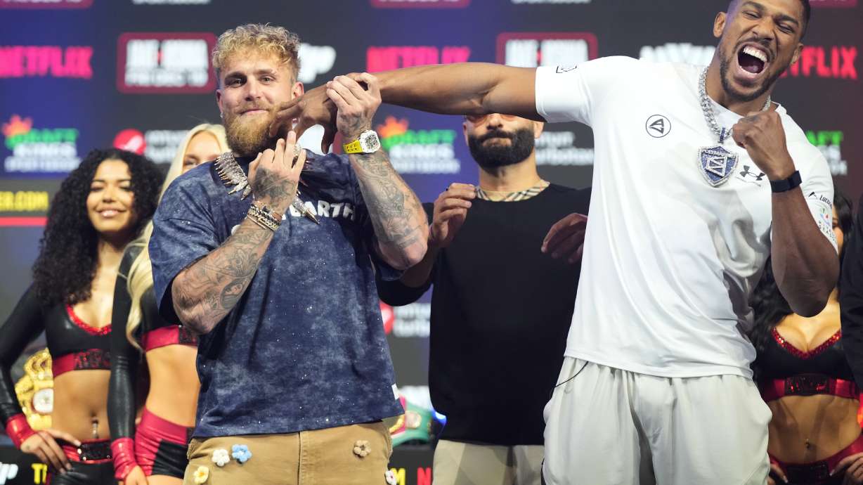 Jake Paul, left, and Anthony Joshua face off during a news conference promoting their upcoming heavyweight boxing match, Wednesday, Dec. 17, 2025, in Miami Beach, Fla.