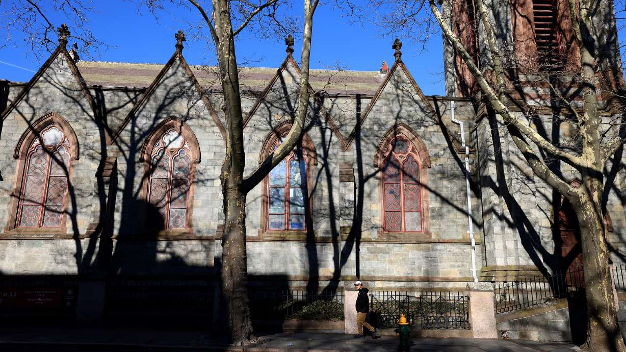 A Brown University student walks past a church on the Providence, RI, campus, Thursday. Authorities are investigating a connection between the mass hooting at Brown University and the killing of an MIT professor two days later.