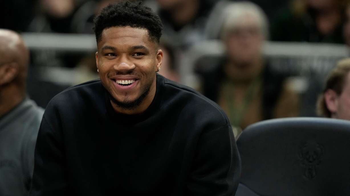 Milwaukee Bucks' Giannis Antetokounmpo smiles from the bench during the first half of an NBA basketball game against the Boston Celtics, Thursday, Dec. 11, 2025, in Milwaukee.