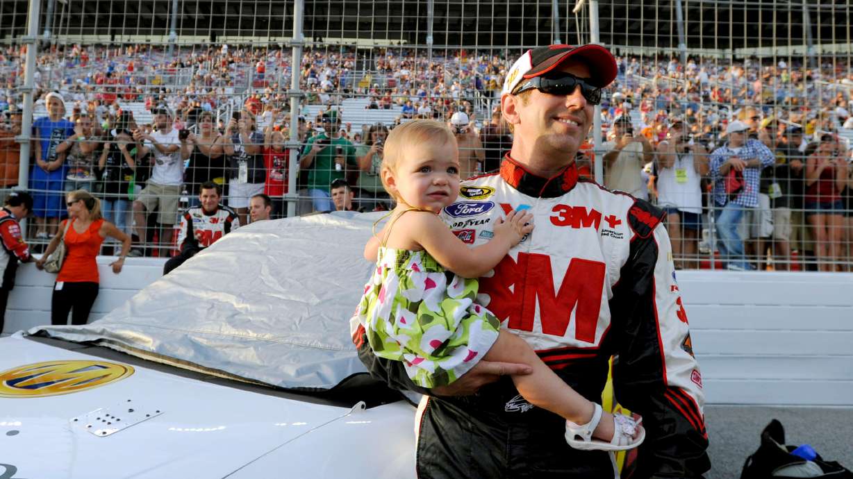 Greg Biffle holds his daughter, Emma, before the NASCAR Sprint Cup Series auto race at Atlanta Motor Speedway, Sunday, Sept. 2, 2012, in Hampton, Ga.