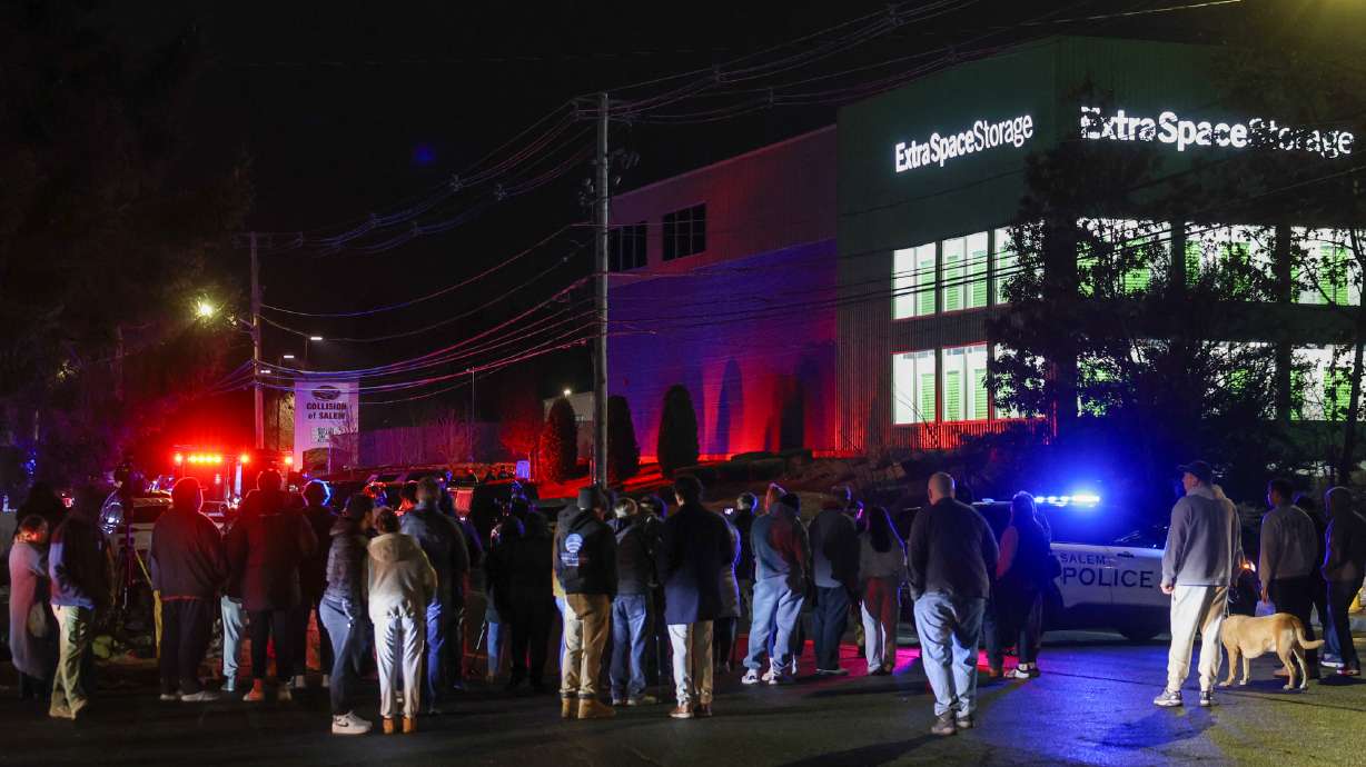 People gather outside a storage facility where a suspect in the shooting at Brown University was found dead, Thursday. Claudio Neves Valente, 48, a former Brown student and Portuguese national, suspected in the shooting, was found dead from a self-inflicted gunshot wound.