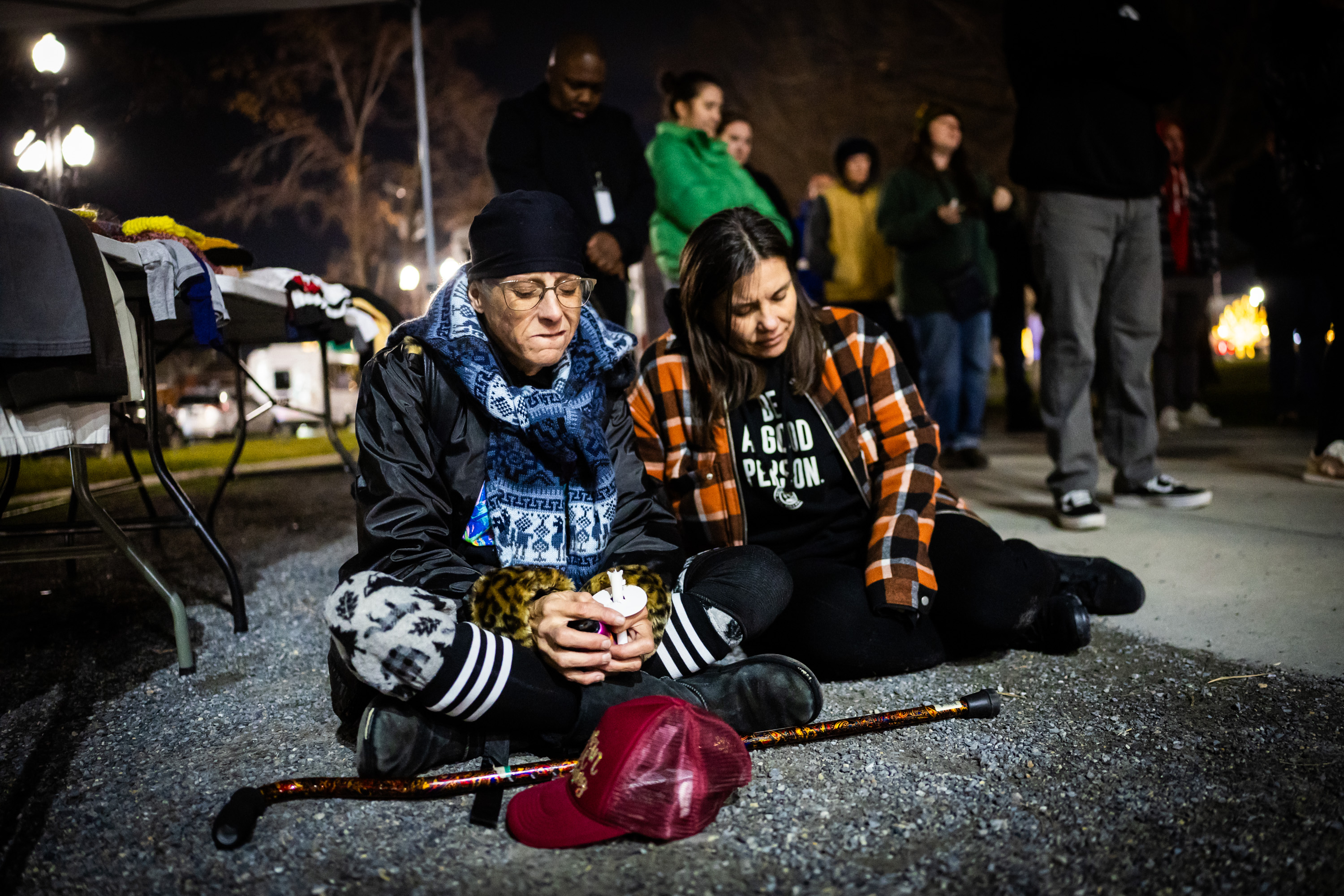 Tamara Walker, Showers of Hope employee, left, and Tiffany Holdaway, an Other Side Village Academy graduate, right, pray after the names of those who died in 2025 while experiencing homelessness or having been homeless were read during the 2025 Homeless Persons' Memorial Vigil at Pioneer Park in Salt Lake City on Thursday.