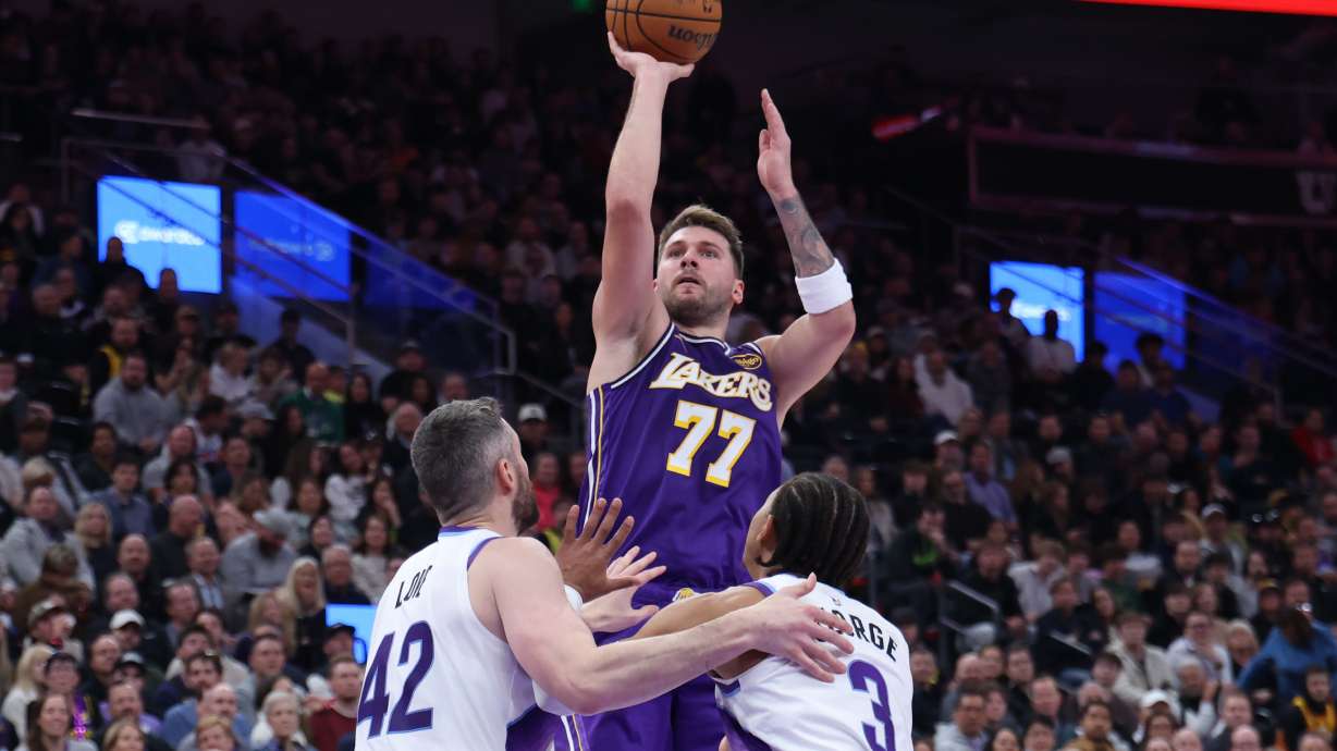 Los Angeles Lakers guard Luka Doncic (77) shoots over Utah Jazz forward Kevin Love (42) and guard Keyonte George (3) during the second half of an NBA basketball game, Thursday, Dec. 18, 2025, in Salt Lake City.