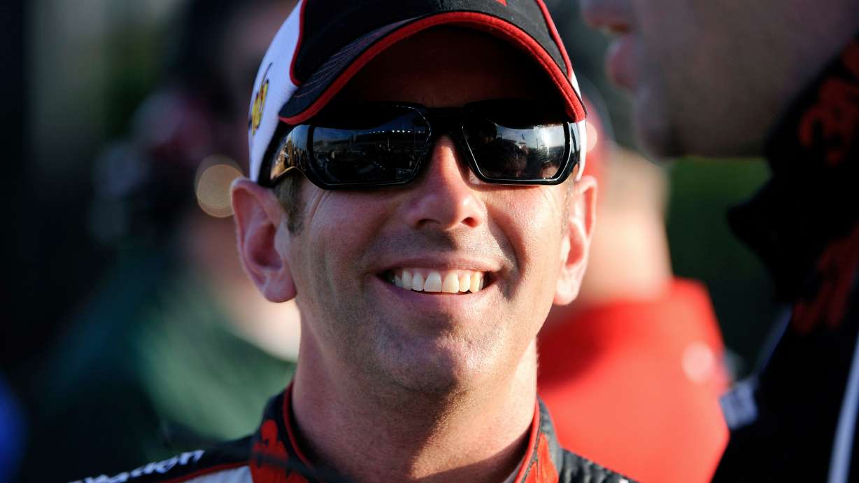FILE - Greg Biffle smiles along pit row during qualifying for Sunday's NASCAR Sprint Cup Series auto race at Atlanta Motor Speedway, Friday, Aug. 31, 2012, in Hampton, Ga.