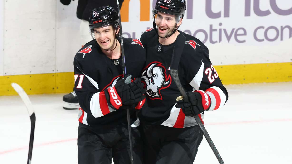 Buffalo Sabres center Ryan McLeod, left, celebrates his empty net goal with defenseman Mattias Samuelsson (23) during the third period of an NHL hockey game against the Philadelphia Flyers, Thursday, Dec. 18, 2025, in Buffalo, N.Y.