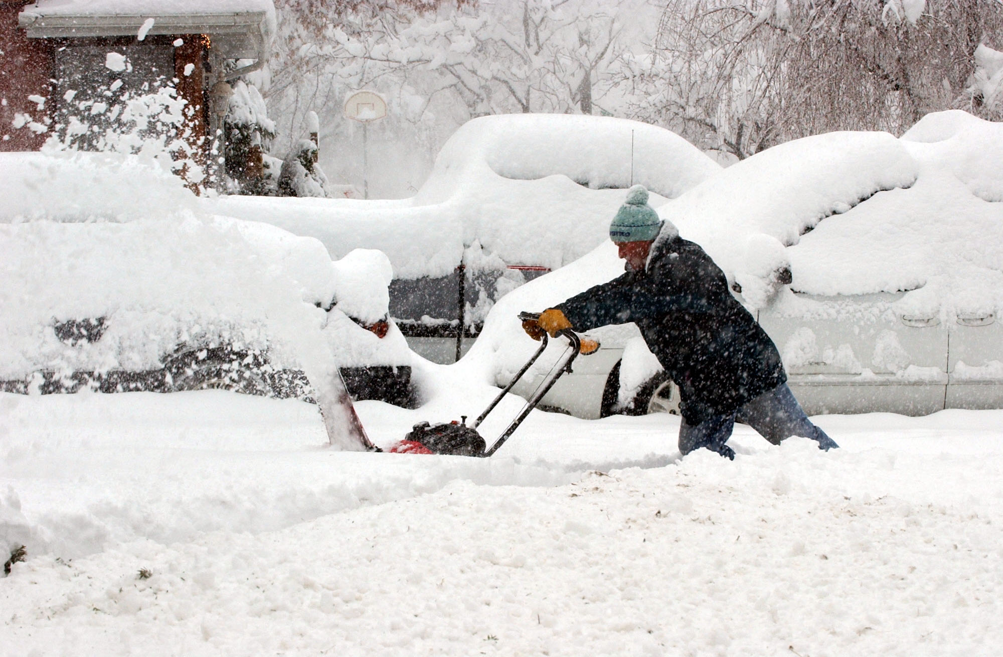 Tom Smith uses his snowblower to clear his neighbor's driveway on Evergreen Avenue in Salt Lake City during a snowstorm on Dec. 26, 2003.