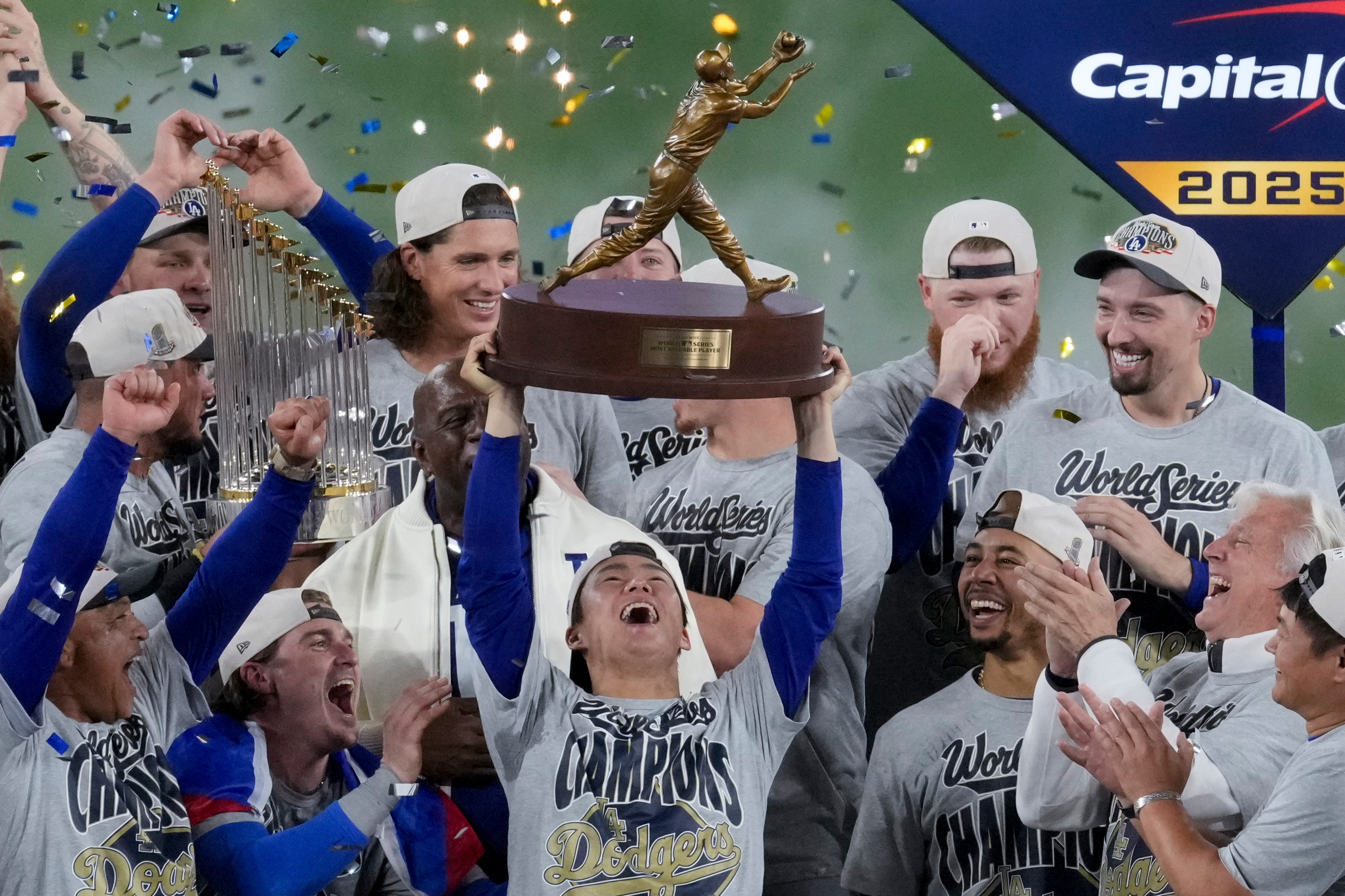FILE - Los Angeles Dodgers World Series MVP Yoshinobu Yamamoto holds his trophy as teammates celebrate their win in Game 7 of baseball's World Series against the Toronto Blue Jays, Sunday, Nov. 2, 2025, in Toronto.