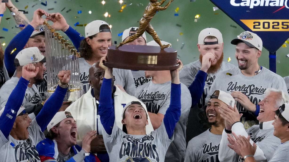 FILE - Los Angeles Dodgers World Series MVP Yoshinobu Yamamoto holds his trophy as teammates celebrate their win in Game 7 of baseball's World Series against the Toronto Blue Jays, Sunday, Nov. 2, 2025, in Toronto.