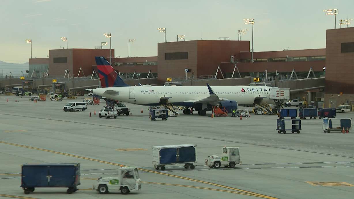 A Delta Air Lines plane sits at the gate at Salt Lake City International Airport, Friday. Officials are advising travelers to arrive much earlier than normal due to the start of holiday travel.