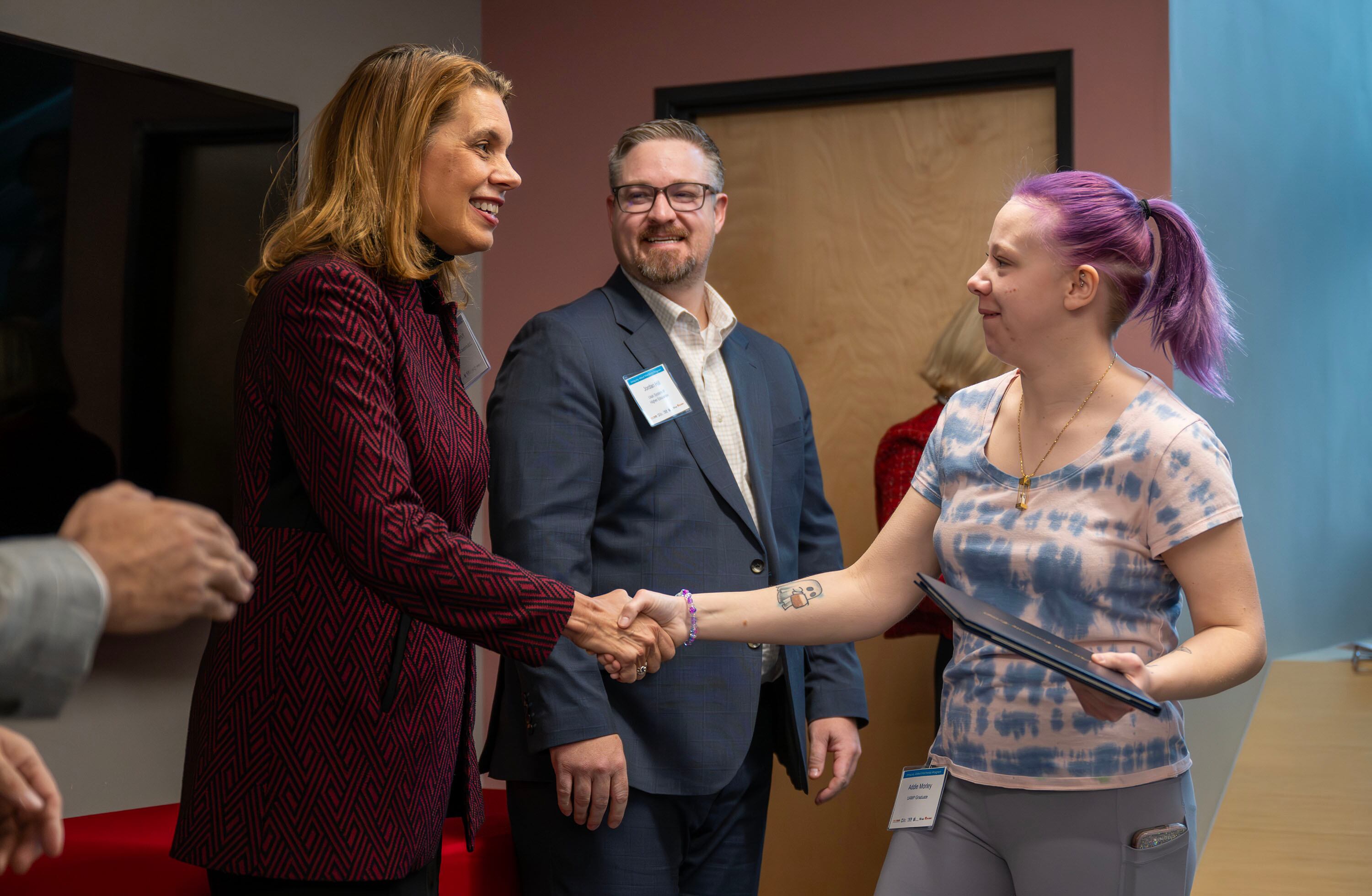 Kristy Chambers, CEO of Columbus Community Center, congratulates Addie Morley as she receives her certificate of completion at the inaugural graduation exercises of a SLCC-sponsored vocational training program for adults with autism at Nextwork Autism Program in South Salt Lake City, on Friday. Morley accepted a job offer to make parts for Boeing.