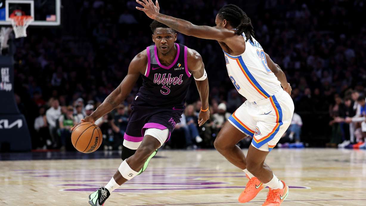Minnesota Timberwolves guard Anthony Edwards, left, works around Oklahoma City Thunder guard Cason Wallace, right, during the first half of an NBA basketball game Friday, Dec. 19, 2025, in Minneapolis.