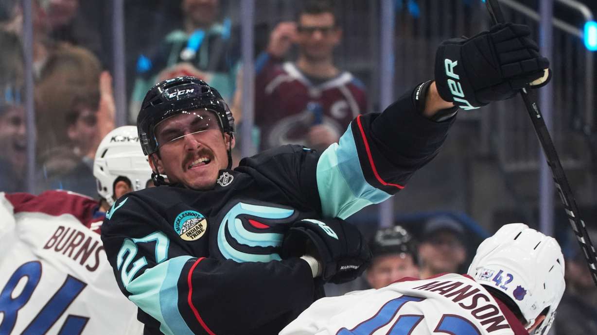 Seattle Kraken left wing Mason Marchment, left, swings at Colorado Avalanche defenseman Josh Manson (42) during a fight during the third period of an NHL hockey game Tuesday, Dec. 16, 2025, in Seattle.