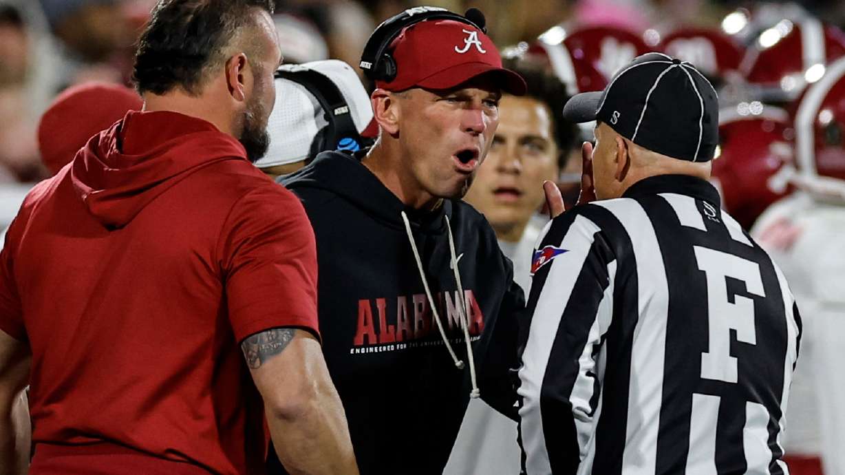 Alabama head coach Kalen Deboer, center, speaks with an official during the first half in the first round of an NCAA College Football Playoff against Oklahoma, Friday, Dec. 19, 2025, in Norman, Okla.
