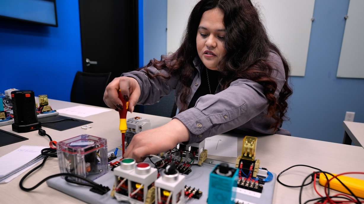 Maintenance technician Liz Cardenas completes a task on an electronics test platform at a training area in a Walmart distribution center Sept. 25, in Bentonville, Ark.