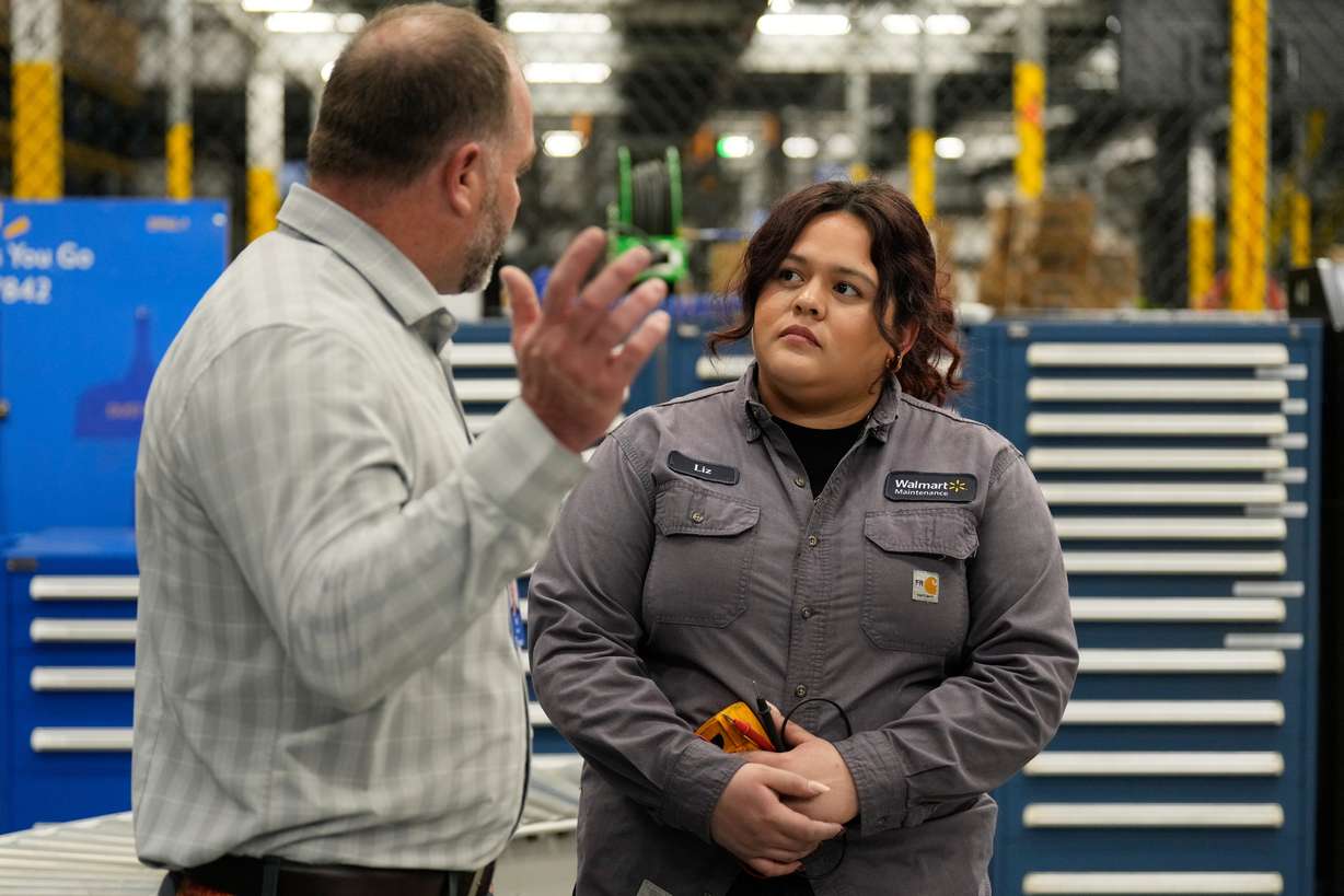 Walmart maintenance technician Liz Cardenas talks to R.J. Zanes, vice president of facility services, at a training area in a Walmart distribution center Sept. 25, in Bentonville, Ark.