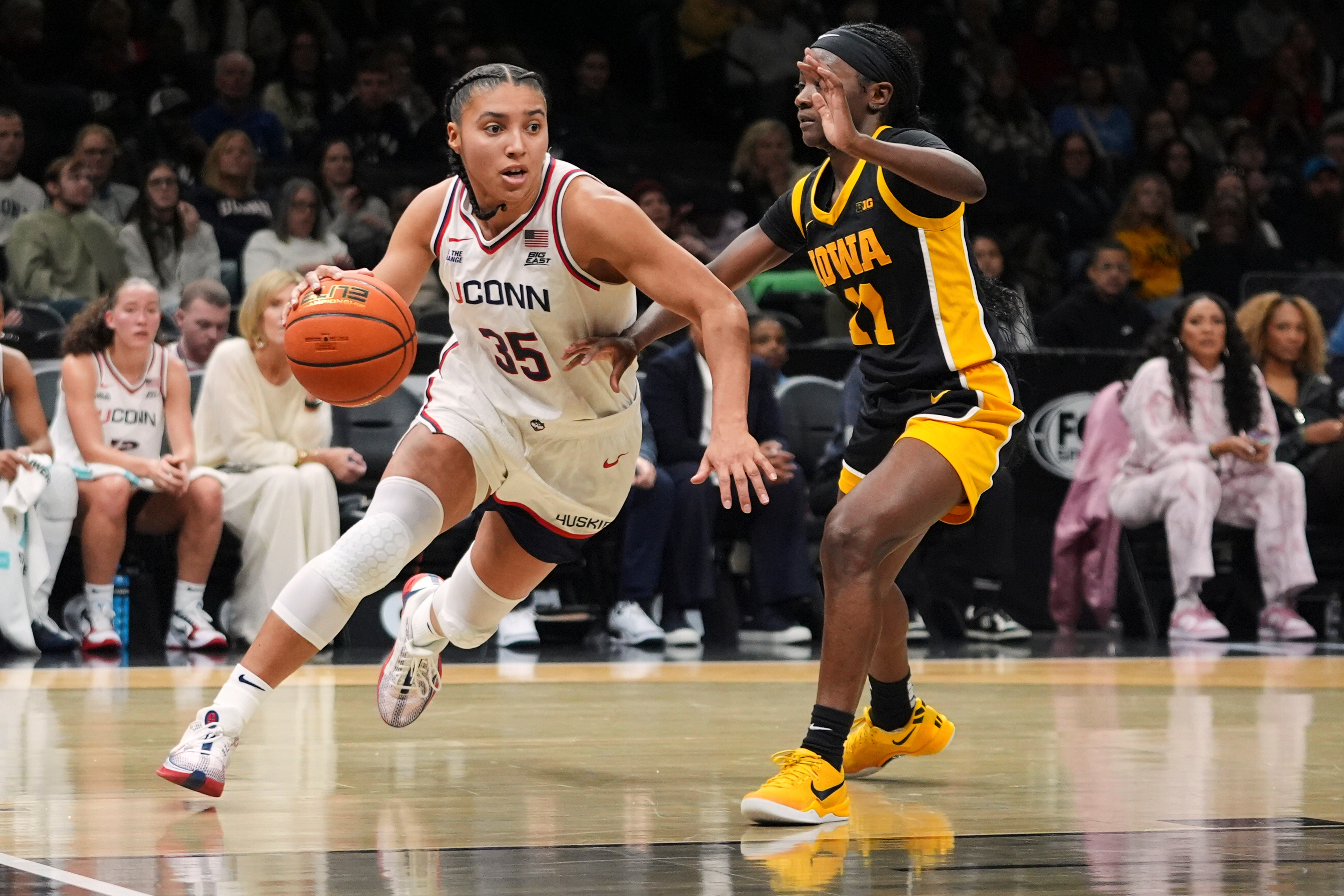 UConn's Azzi Fudd (35) drives past Iowa's Chazadi Wright (11) during the second half of an NCAA college basketball game Saturday, Dec. 20, 2025, in New York.