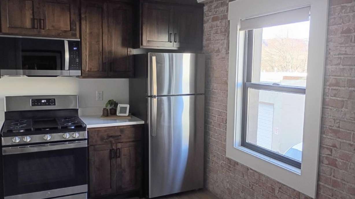Old brickwork is paired with modern appliances in a sparkling new kitchenette inside one of the newly remodeled suites at The Suites of Lava Hot Springs.