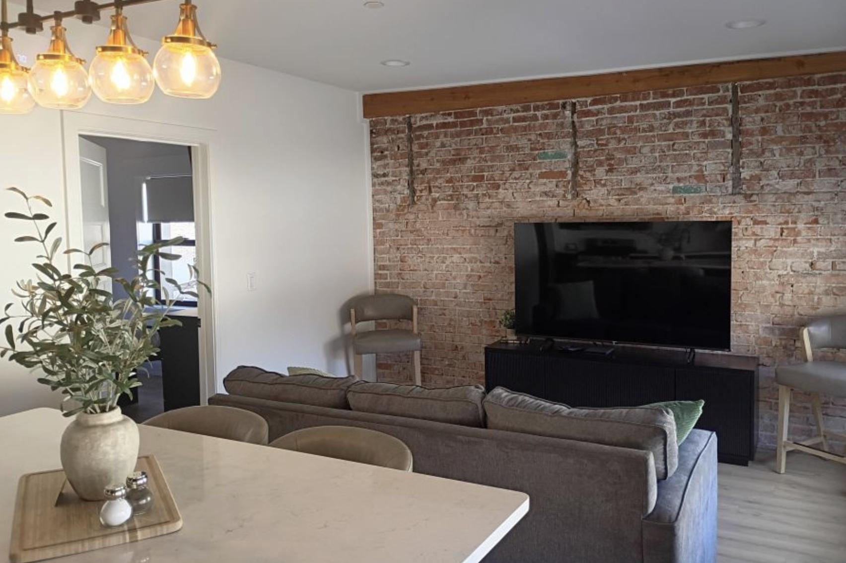 Classic brick surrounds a high-tech TV in the Idaho Falls–themed suite at The Suites of Lava Hot Springs.