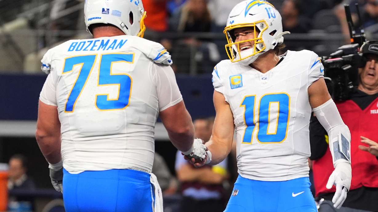Los Angeles Chargers quarterback Justin Herbert (10) celebrates his touchdown with center Bradley Bozeman (75) during the first half of an NFL football game against the Dallas Cowboys, Sunday, Dec. 21, 2025, in Arlington, Texas.