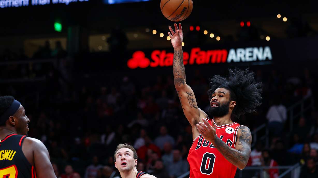 Chicago Bulls guard Coby White (0) shoots over Atlanta Hawks forward Onyeka Okongwu, left, during the first half of an NBA basketball game, Sunday, Dec. 21, 2025, in Atlanta.