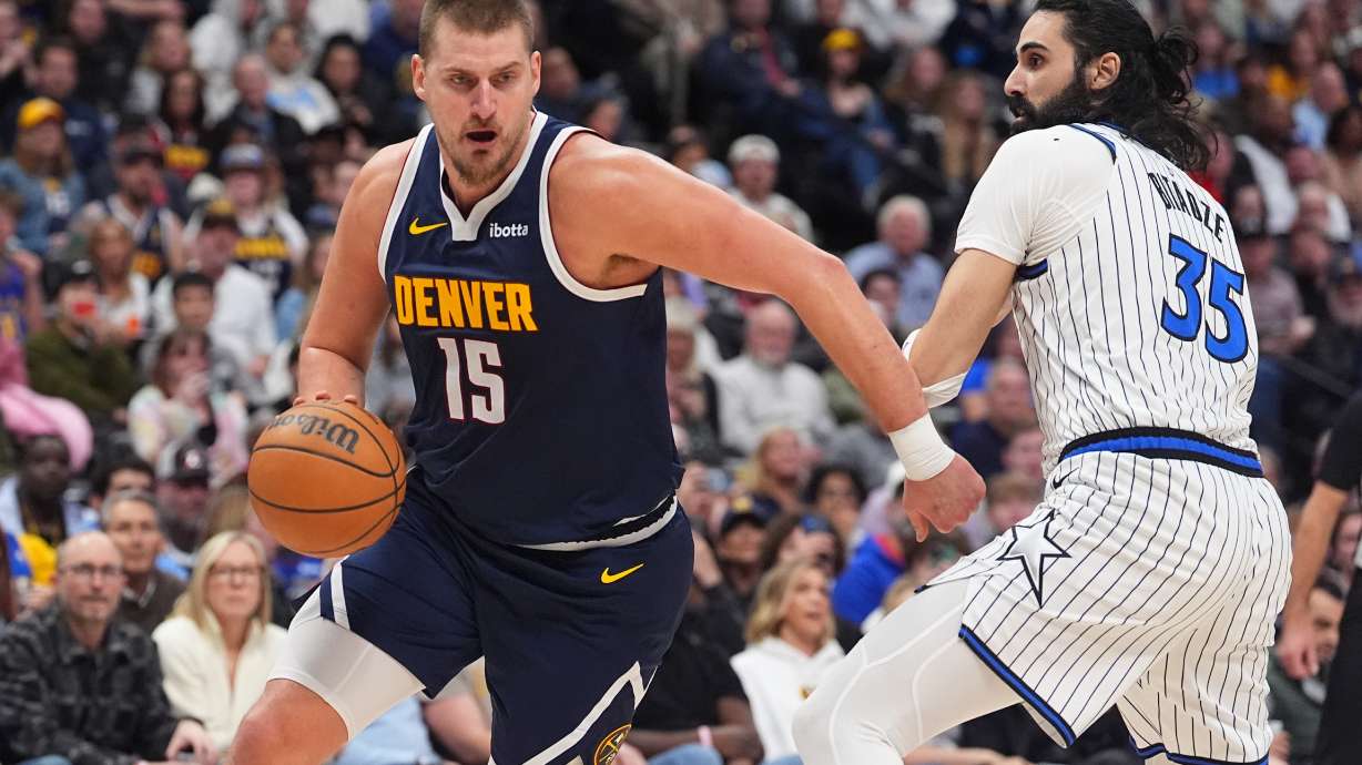 Denver Nuggets center Nikola Jokić drives (15) past Orlando Magic center Goga Bitadze (35) in the second half of an NBA basketball game Thursday, Dec. 18, 2025, in Denver.