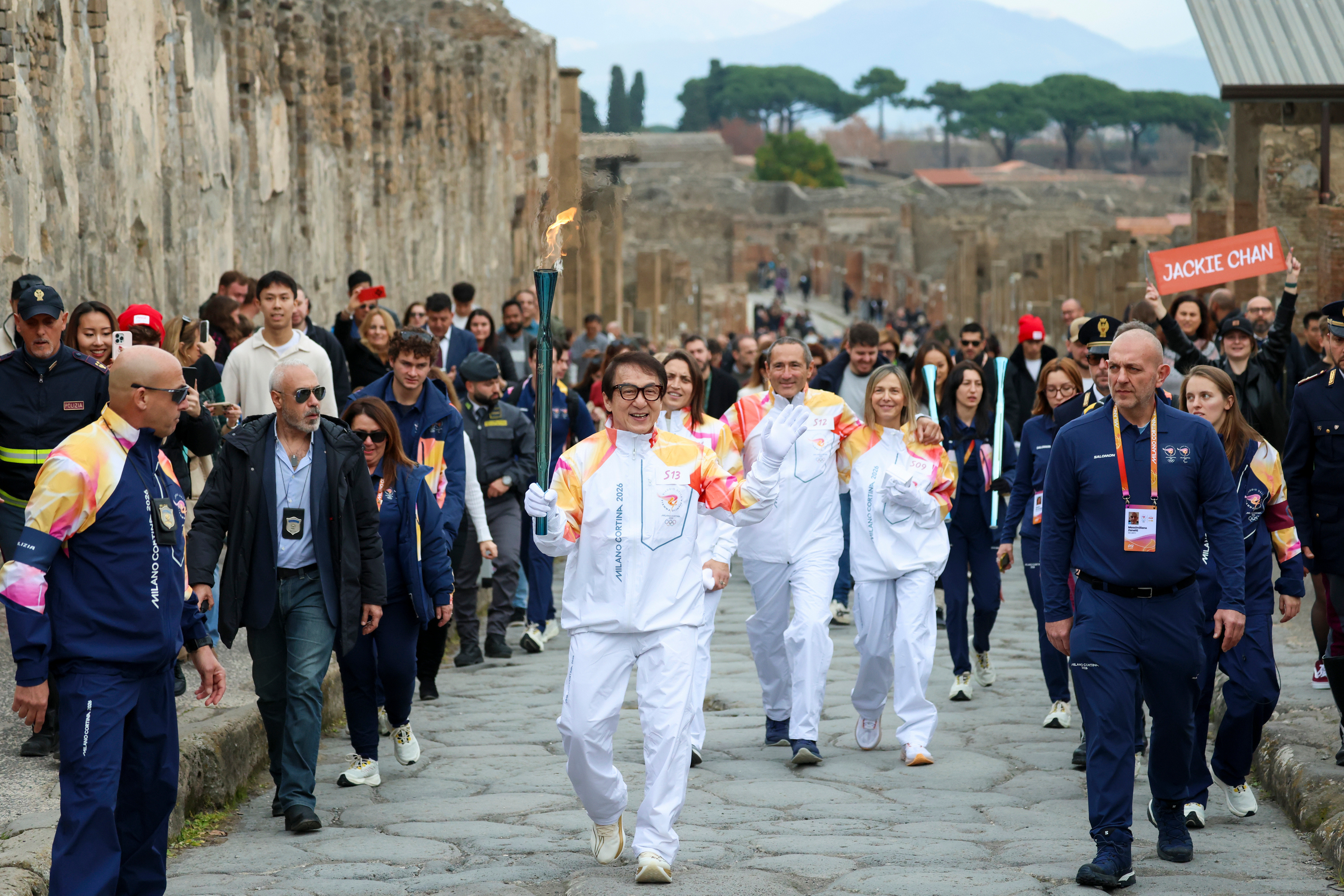 Jackie Chan carries the Milan Cortina Olympic torch through the ruins of Pompeii