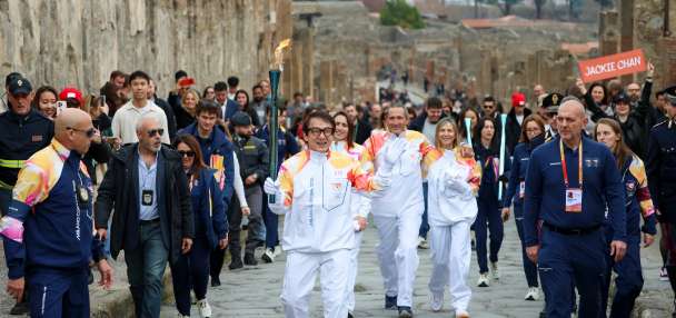 Jackie Chan carries the Milan Cortina Olympic torch through the ruins of Pompeii