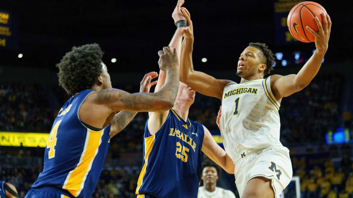 Michigan guard Trey McKenney (1) looks to shoot over La Salle guard Truth Harris (4) and forward Bowyn Beatty (25) during the second half of an NCAA college basketball game, Sunday, Dec. 21, 2025, in Ann Arbor, Mich.