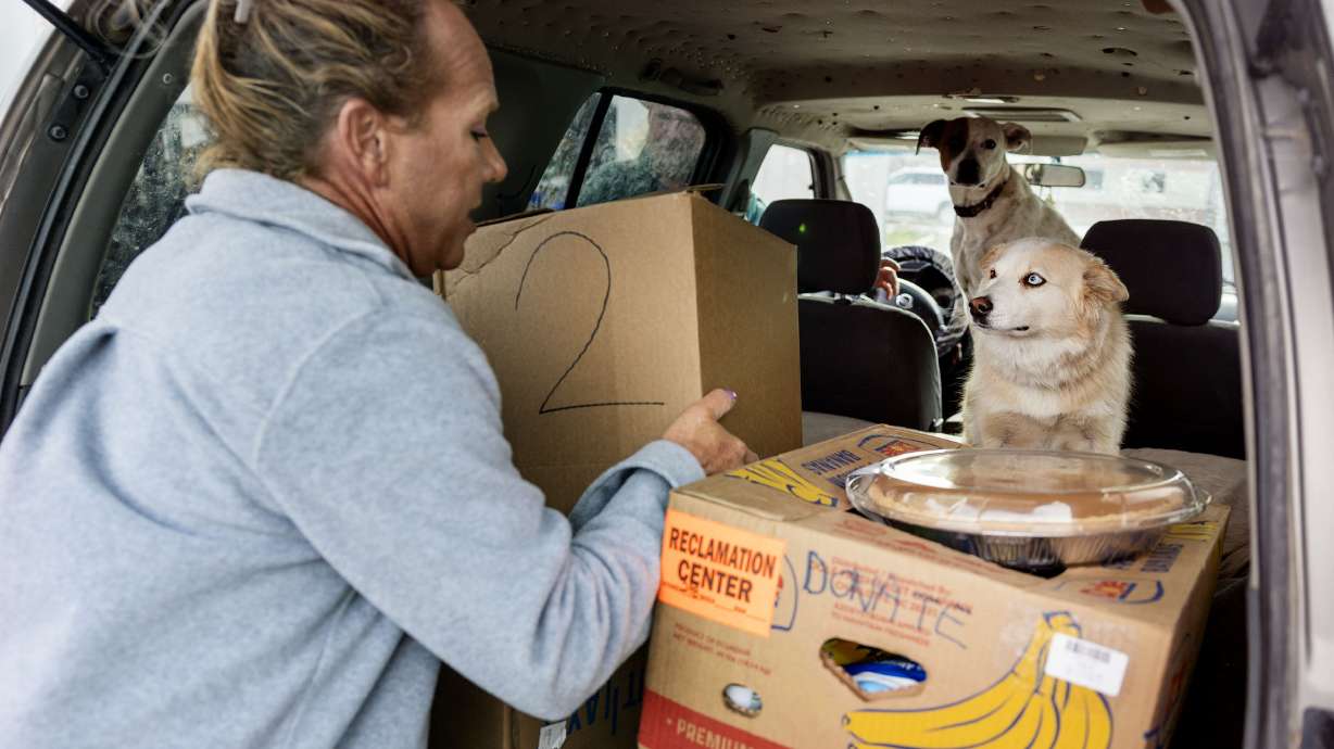 Michael Anderson places a box of food into a car during the Salt Lake City Mission’s annual “Christmas Food Box Giveaway” in Salt Lake City on Monday.