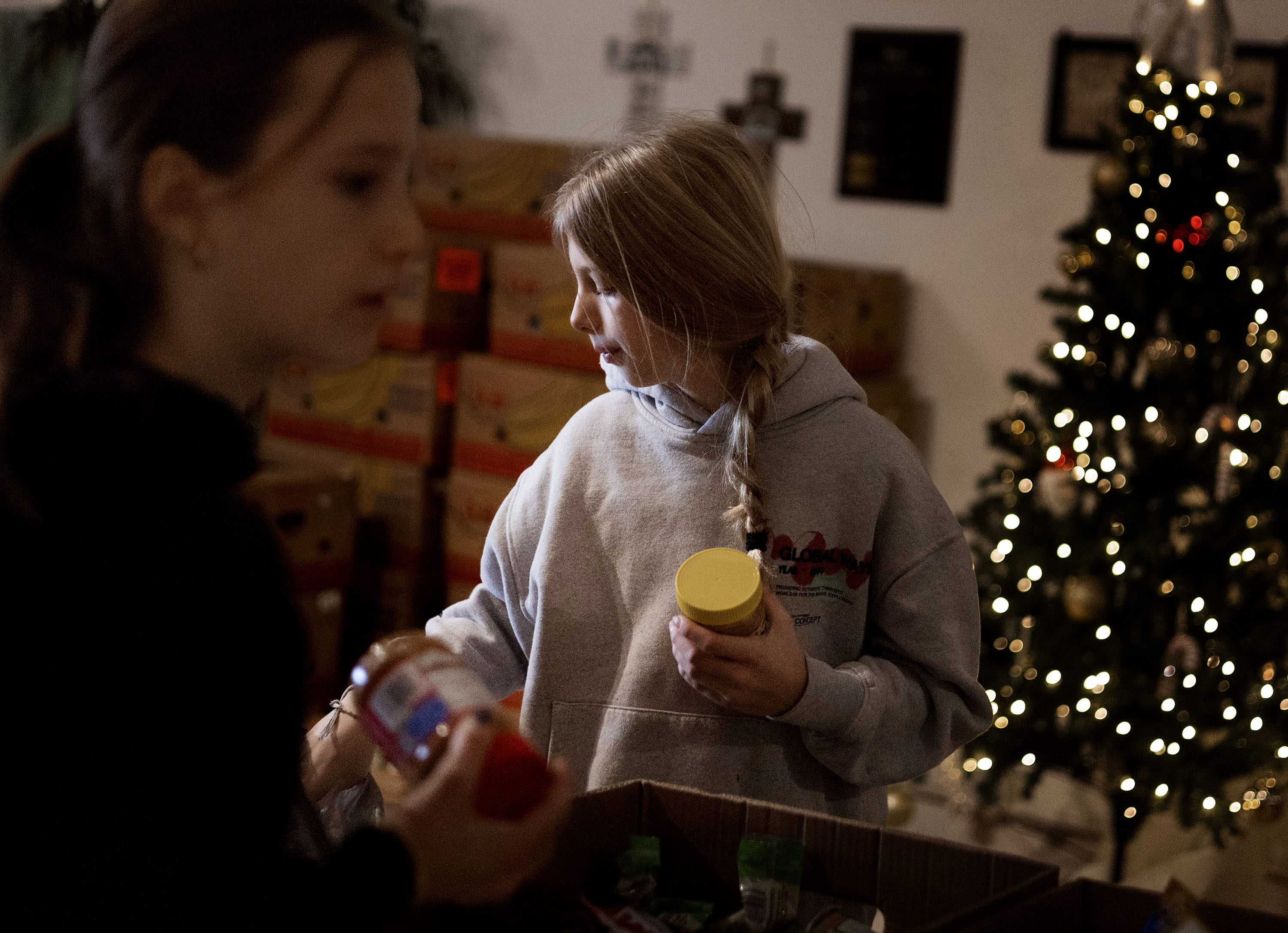 Sisters Serena and Anna Fisher of Salt Lake City fill food boxes during the Salt Lake City Mission’s annual “Christmas Food Box Giveaway” in Salt Lake City on Monday.