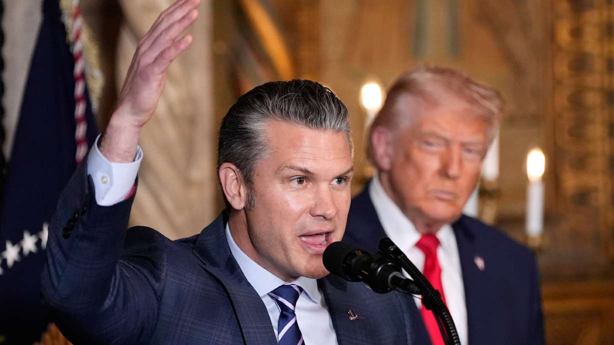 Defense Secretary Pete Hegseth speaks as President Donald Trump looks on, at Trump's Mar-a-Lago club, Monday in Palm Beach, Fla.
