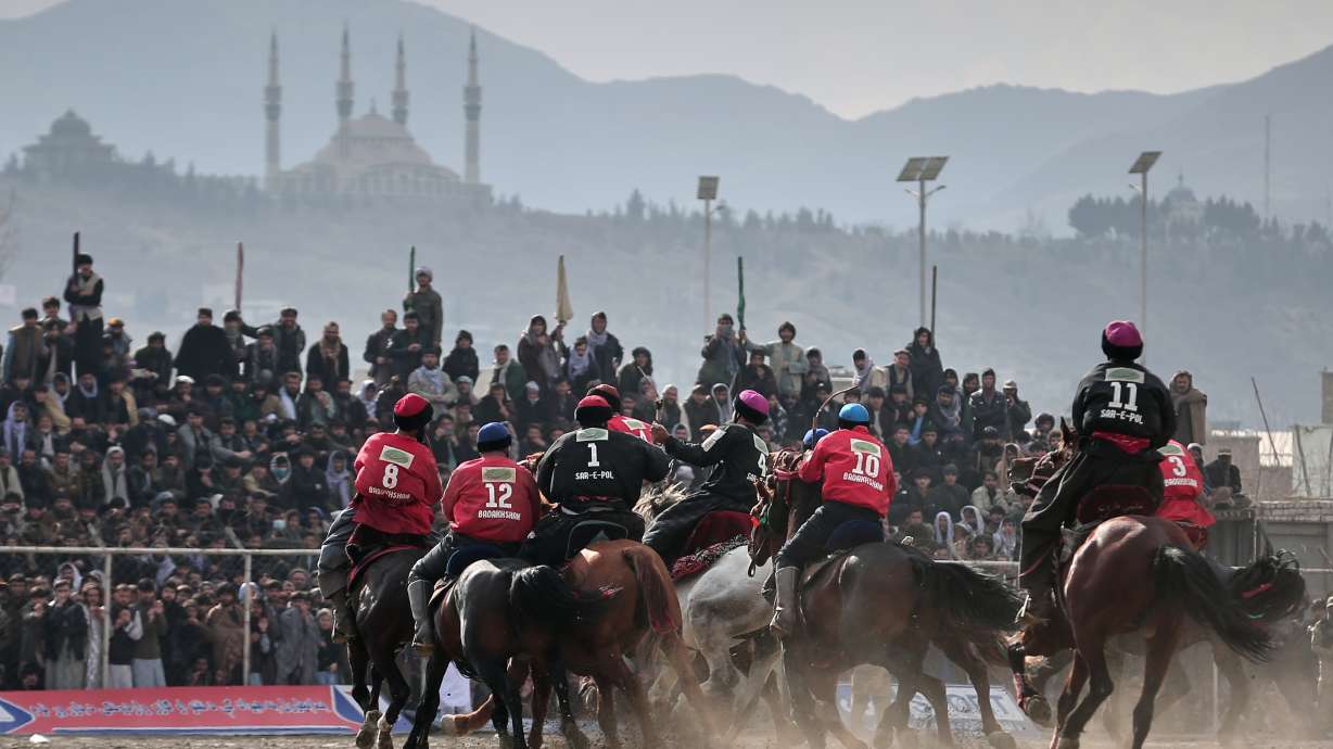 Riders from the Sar-e-Pul and Badakhshan teams compete in the final of Afghanistan's annual buzkashi tournament, a traditional equestrian sport in which riders score points using a fake goat carcass, on the outskirts of Kabul, Afghanistan, Monday, Dec. 22, 2025.